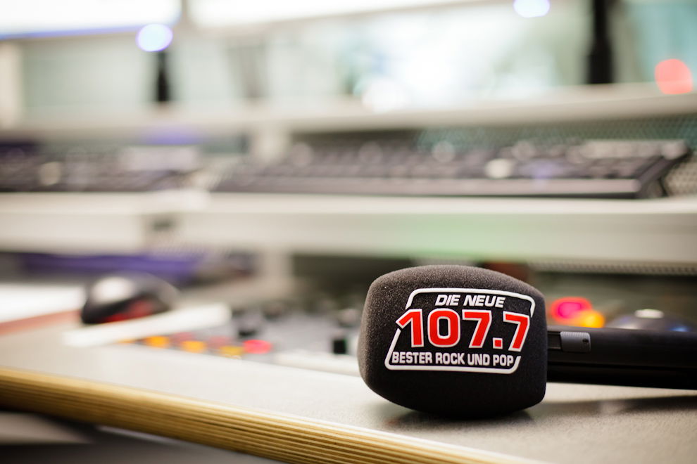 Ein Mikrofon mit DIE NEUE 107.7 Popschutz liegt auf dem Mischpult in unserem Nachrichtenstudio