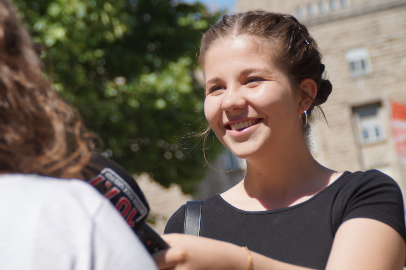 Eine Mitarbeiterin führt ein Interview auf der Straße