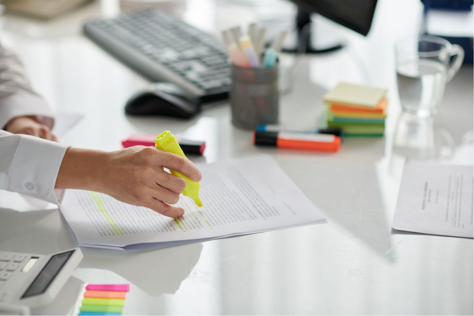 Hand, die wichtige Stellen in einem Dokument markiert oder anstreicht