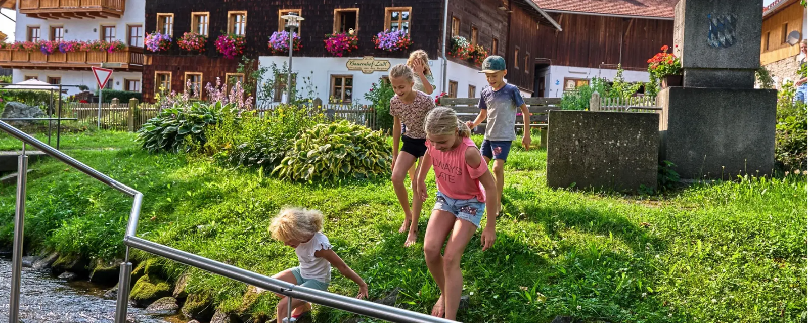 Spielende Kinder an einem Bach